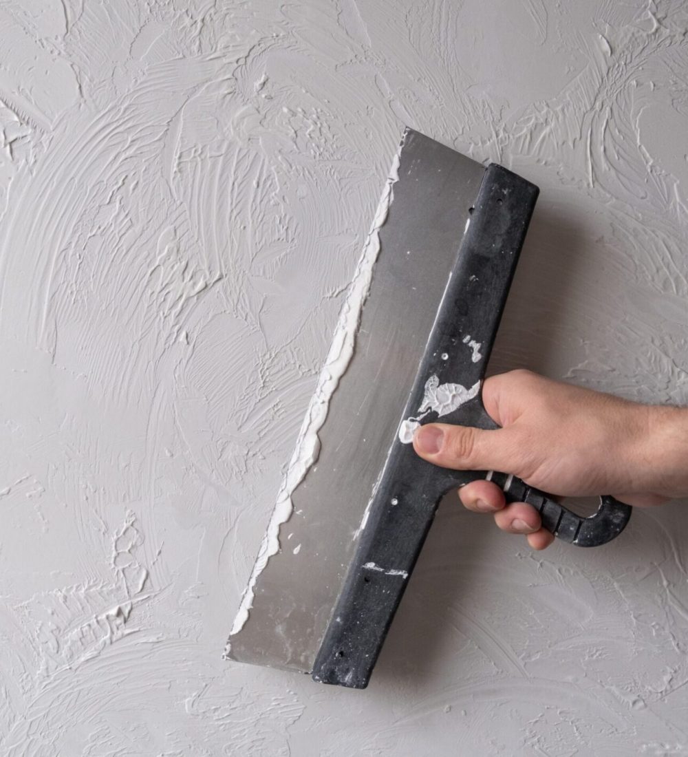 Applying decorative putty. White abstract texture of surface covered with putty