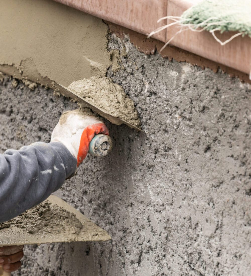 Tile Worker Applying Cement with Trowel at Pool Construction Site.